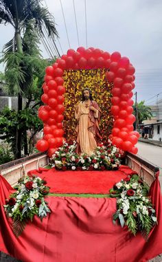 a red blanket on the back of a truck with a statue of jesus in it