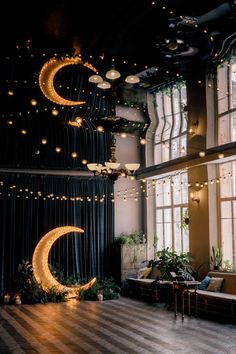 a large room with lights hanging from the ceiling and moon decorations on the wall above it