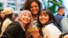 three women smile and pose for the camera