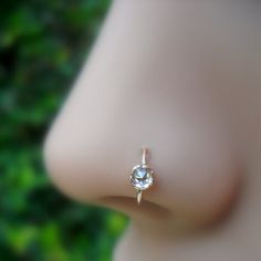 a close up view of a diamond ring on the tip of someone's nose