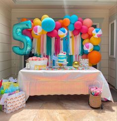 a table topped with balloons and cake