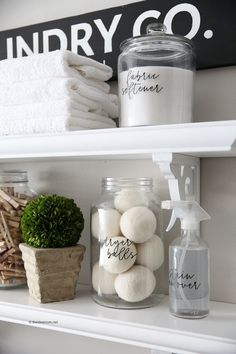 bathroom shelves with towels, plants and jars on top of them in front of a sign that says laundry co