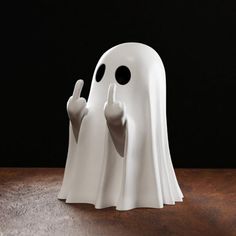 a white ghost figurine sitting on top of a wooden table