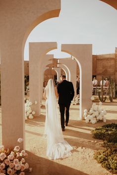 a bride and groom walking down the aisle at their outdoor wedding ceremony in desert setting