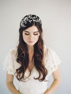 a woman with long hair wearing a white dress and a tiara on her head