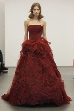 a woman in a red dress on the runway