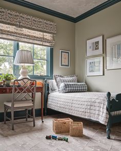 a bedroom with a bed, desk and pictures on the wall