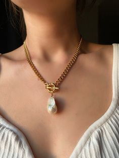 ✨ Want to add an elegant and unique piece of jewelry to your collection? Handmade with care and attention to detail, this necklace is crafted from brass and 22k gold-plated. The focal point of the necklace is the beautiful luminous baroque pearl which adds a touch of natural beauty to the piece. ✨ The charm of this unique real pearl pendant necklace is heightened by the baroque pearl's natural beauty and glittery reflections. Its golden brass base adds a touch of glamor to the piece, making it p Unique Chunky Chain Necklaces For Gifts, Unique Chunky Chain Necklaces As Gift, Vintage Gold Pearl Necklace With Clavicle Chain, Gold Vintage Pearl Necklace With Clavicle Chain, Elegant Brass Toggle Necklace, Unique Chunky Chain Jewelry For Gift, Unique Gold Necklace With Chain, Gold Metal Necklaces With Pearl Chain, Gold Metal Necklace With Pearl Chain