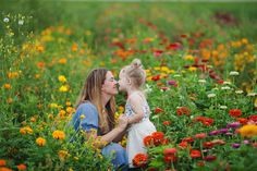 a mother and her daughter sitting in a field of flowers