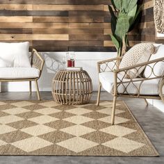 two chairs and a table in front of a wall with wood planks on it