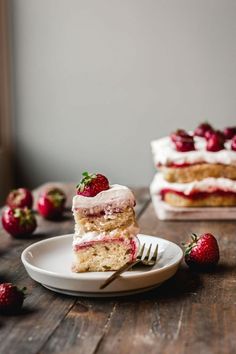 two slices of cake on plates with strawberries