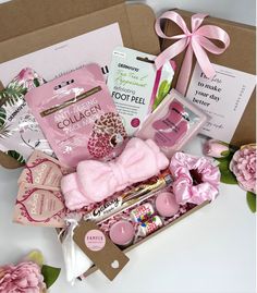 a pink gift box filled with personal care items next to a card and envelopes