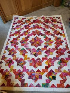 a large quilt is laying on the floor