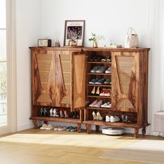 a wooden cabinet filled with lots of shoes next to a white wall and hardwood floor