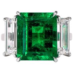 This stunning three stone emerald and diamond ring is crafted in solid platinum. Showcasing a prominent high quality genuine rectangular emerald-cut Colombian emerald approx. 6.70 carats with no treatments, except minor oil and measuring 13.00 x 10.80 x 7.06mm. Further ornamented by two rectangular step cut GIA certified diamonds at its sides weighing approx. 1.42 carats, graded E color, and VS2 clarity and 1.39 carats, graded F color, and VS1 clarity. Ring size 6, can be resized upon request. I Colombian Emerald Ring, Smaragd Ring, Columbian Emeralds, Emerald Cut Diamond Ring, Platinum Diamond Rings, Emerald Diamond Ring, Colombian Emeralds, Stone Engagement Rings, Emerald Jewelry