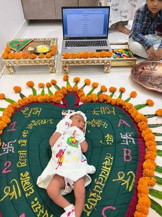 a baby is laying in front of a cake with writing on it and orange flowers