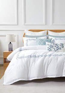 a bed with white and blue comforters in a room