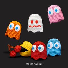 four crocheted toys with eyes and mouths are arranged in a row on a black background