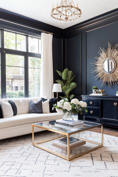 a living room with black walls, white furniture and a gold coffee table in the middle