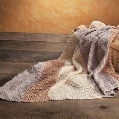 a basket filled with blankets on top of a wooden floor