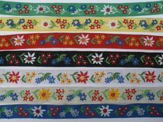 colorful ribbons with flowers and leaves on them, all lined up in the same row