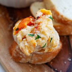 a close up of bread on a cutting board with eggs and cheese in the middle