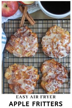 apples and cinnamon rolls on a cooling rack next to an apple, cinnamon sticks, and cup of coffee