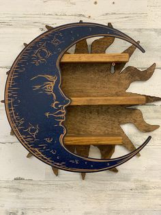 a wooden shelf with two shelves on it and a moon face cut out of the wood