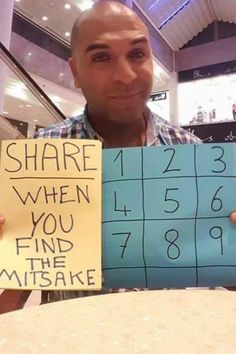 a man holding up a sign that says share when you find the mistake