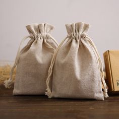 two linen bags sitting on top of a wooden table