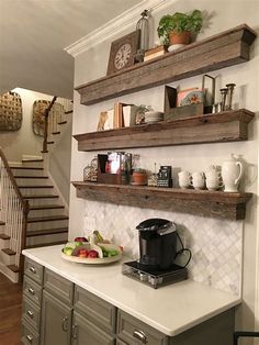 an image of a kitchen with shelves above the counter and coffee maker on the wall