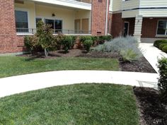 an apartment building with landscaping in front of it