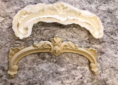 two ornate brackets sitting on top of a marble counter