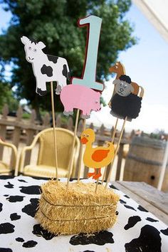 a table topped with cake toppers covered in animals and farm animals on stick sticks