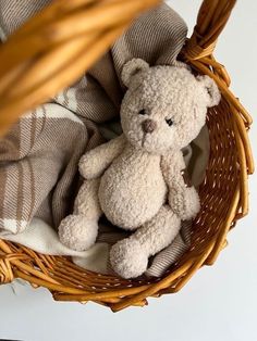 a teddy bear is sitting in a basket