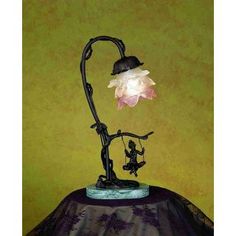 a lamp that is sitting on top of a table with a flower growing out of it