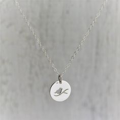 Sterling Silver Bird on a Branch Necklace. Making a great nature lovers gift, this enchanting little charm features a silhouette of a bird on a branch. The bird is a perfect symbol for freedom and perspective. » Sterling Silver Charm (12mm x 12mm) with soldered jump ring and tiny 925 genuine Sterling mark on back. » Sterling Silver Cable Chain (select from drop-down on upper right) » Your jewelry purchase will come beautifully packaged for gift giving. Personalize It: ✧ Add a Birthstone Crystal: Bird Design Necklace Gift, Round Necklace With Bird Design For Gift, Bird Design Round Pendant Jewelry For Gifts, Bird Design Round Pendant Jewelry As Gift, Bird Design Round Pendant Jewelry Gift, Gift Jewelry With Bird Design Round Pendant, Round Pendant Jewelry With Bird Design For Gift, Bird-shaped Bird-design Necklace For Gifts, Bird Design Necklace As A Gift