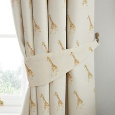 a curtain with giraffes on it is hanging in front of a window