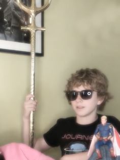 a young man wearing sunglasses and holding up a large golden key