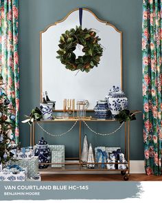 a blue and white christmas display in front of a mirror with a wreath on it