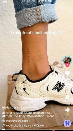 the foot has a small tattoo on it and is next to someone's shoe