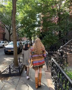 two women are walking down the sidewalk together