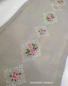 an embroidered table runner with pink flowers on it