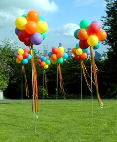 colorful balloons are floating in the air on sticks