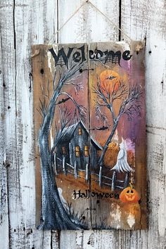 a wooden sign that says welcome to halloween with a house and pumpkins on it