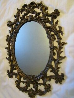 an ornately carved mirror on a white sheet