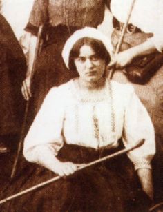 an old black and white photo of two women sitting next to each other, one holding a cane