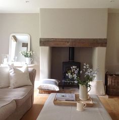 a living room filled with furniture and a fire place in the middle of it's wall