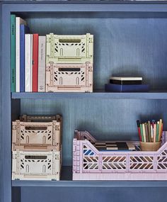 three shelves with books, pencils, and other items on top of each shelf