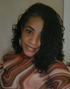 a woman with curly hair is smiling for the camera